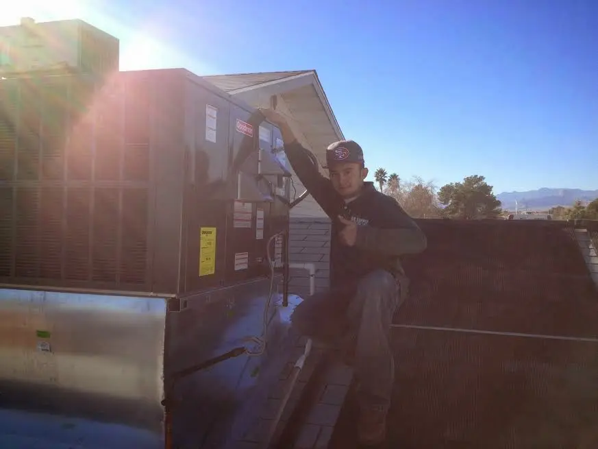 HVAC technician performing Boiler Repair on a rooftop unit in Putnam Valley